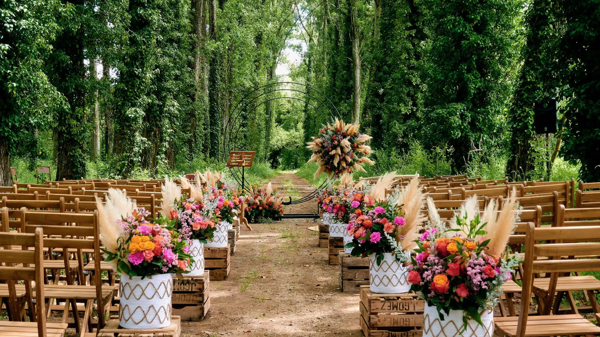 Décoration de mariage YelloEvent, centre de table bohème avec fleurs et pampas sur table en bois pour une réception en extérieur dans le Sud de la France