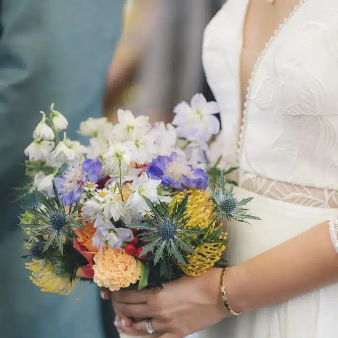 Mariée tenant un bouquet coloré lors d’un mariage dans le Gard organisé par Yello Event