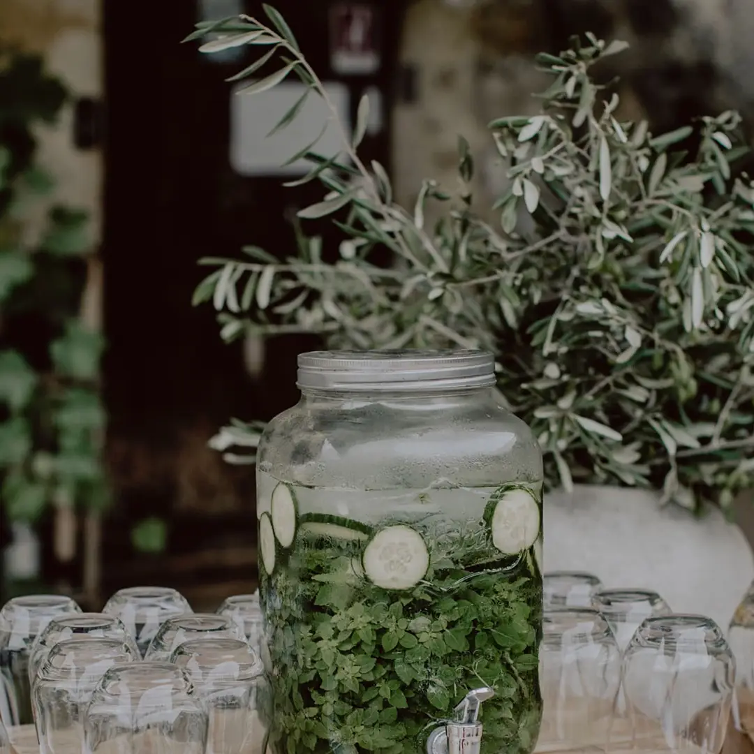 Fontaine en verre remplie d’eau infusée au concombre et à la menthe lors d’un mariage Yello Event