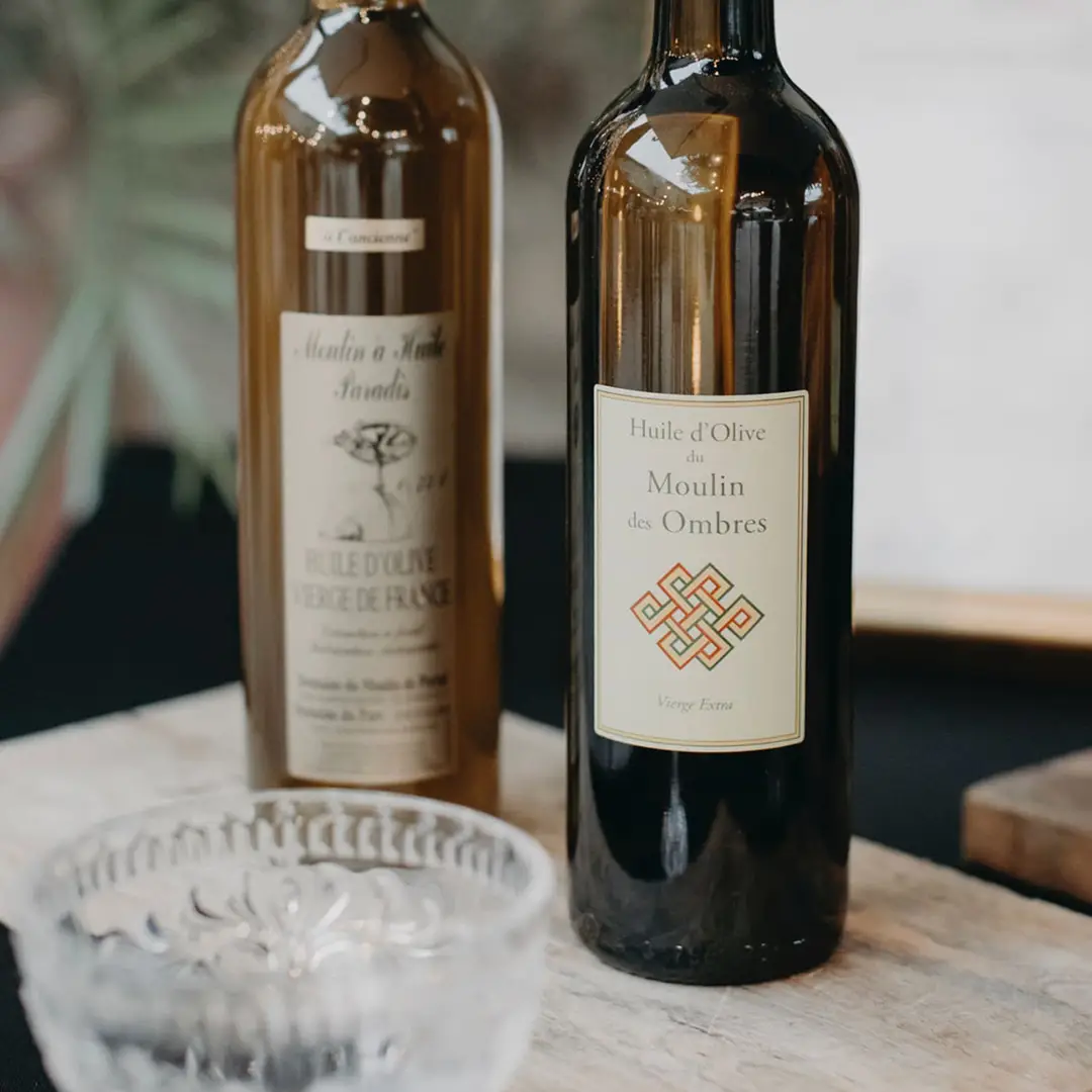 Bouteilles d’huile d’olive artisanale sur table de buffet mariage par Yello Event