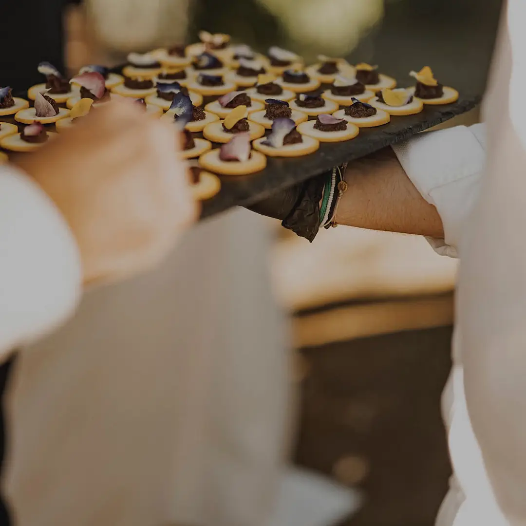 Plateau de canapés apéritifs raffinés garnis de crème, tapenade et pétales de fleurs, servi lors d’un événement par Yello Event dans le Gard
