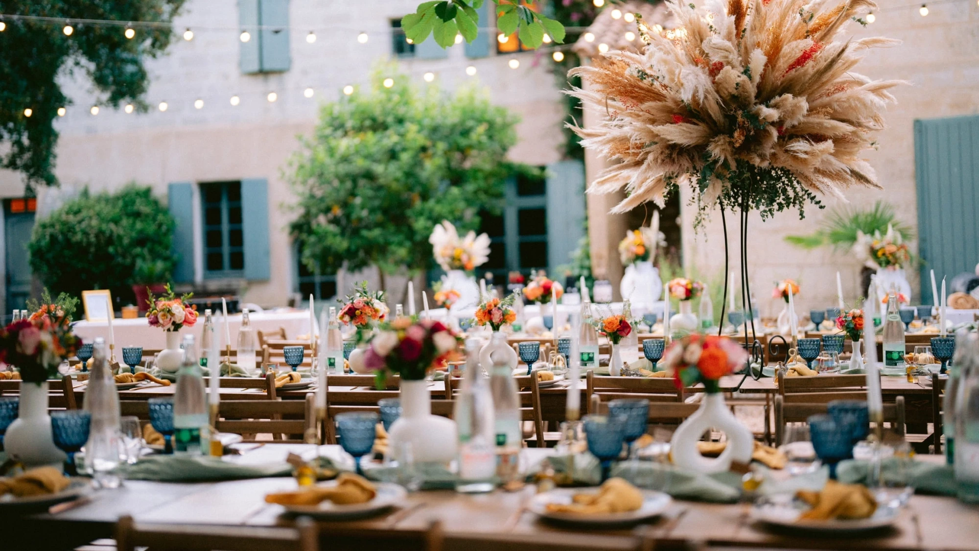 Réception de mariage organisée par YelloEvent dans le Sud de la France, table extérieure élégamment décorée avec compositions florales et pampas séchées
